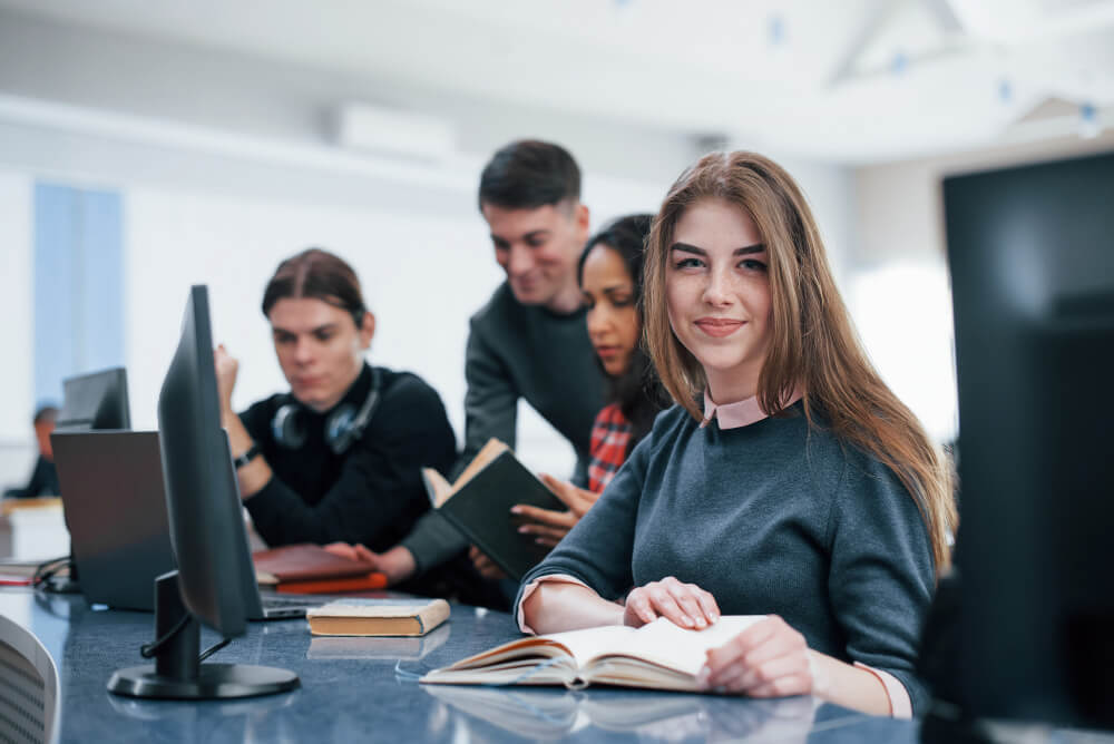 Estudiantes sentados en mesas del aula de clases
