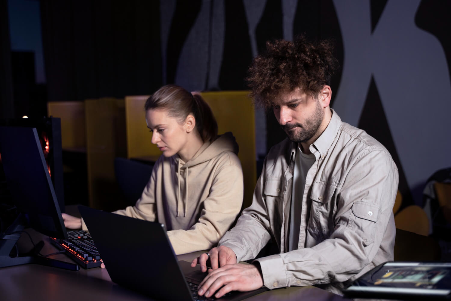 Dos personas trabajando en laptops en una oficina moderna