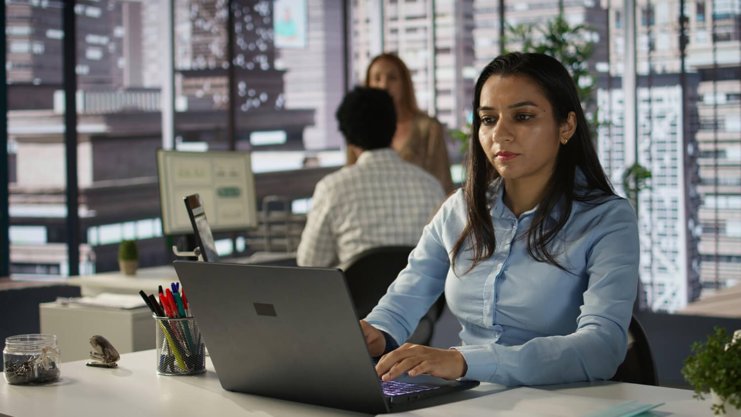 Mujer trabajando en una oficina moderna con un portatil