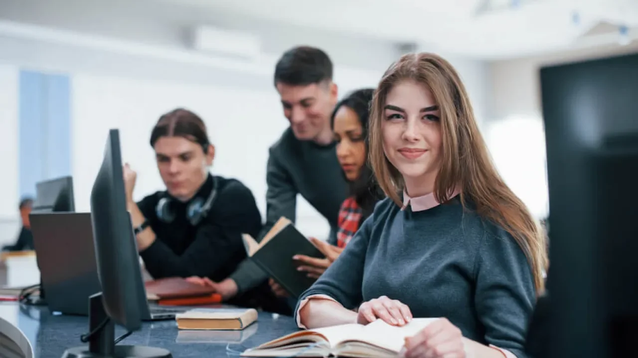 Estudiantes sentados en mesas del aula de clases