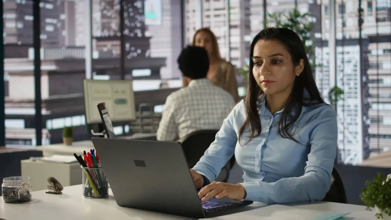 Mujer trabajando en una oficina moderna con un portatil