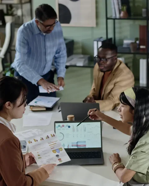 personas trabajando en una sala de juntas analizando datos en computador