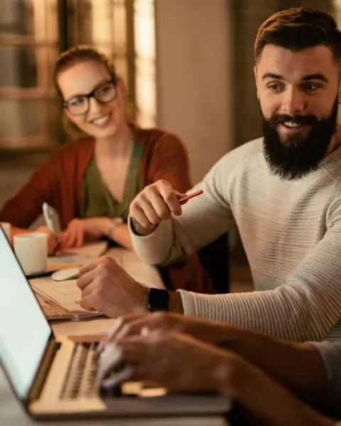 Personas trabajando juntas en portátiles, en un ambiente colaborativo