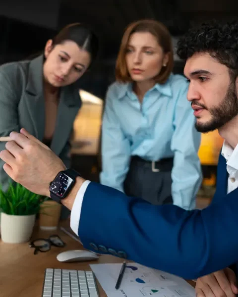 Personas revisando gráficos en una computadora en una oficina