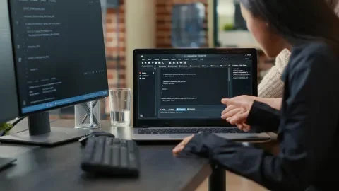 Mujer revisando información en varios monitores de su escritorio