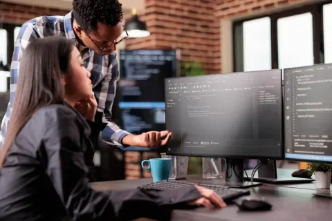 Dos personas trabajando frente a sus monitores