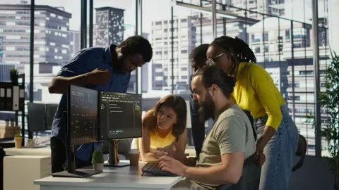 Personas colaborando frente a un computador en una oficina moderna