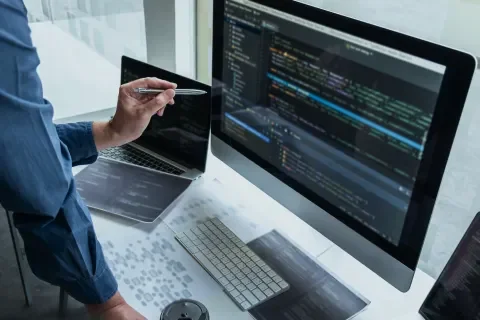Una persona frente a la computadora escribiendo código