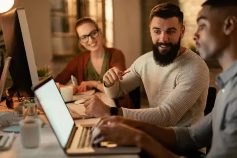Personas trabajando juntas en portátiles, en un ambiente colaborativo