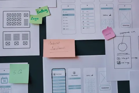 Mobile app wireframes and sticky notes displaying