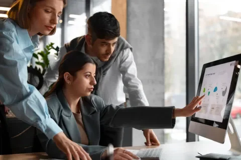 Personas trabajando juntas en una computadora en una oficina moderna