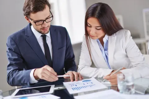 hombre y mujer revisando documentacion en un escritorio